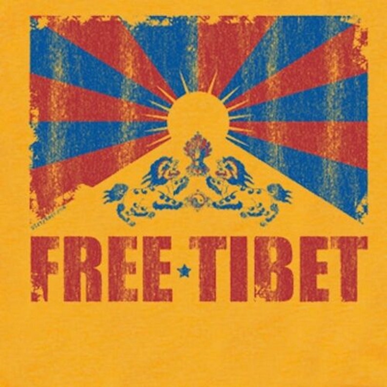 Pu&ograve; includere: Una maglietta gialla con un'immagine usurata della bandiera tibetana e il testo "FREE TIBET" in rosso.