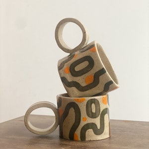 Handmade Speckled Stoneware Cappuccino Mug With A Round Handle: Dark Green and Orange Geometric Design
