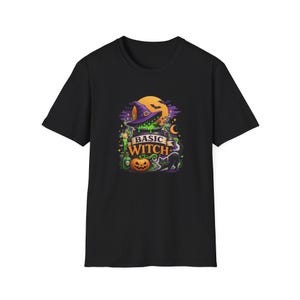 May include: A black short-sleeve t-shirt featuring a graphic print of a purple witch hat, a bubbling green cauldron, a jack-o'-lantern, a black cat, and a candle. The text BASIC WITCH is printed in orange and white letters across the center.
