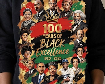 May include: Black sweatshirt featuring a colorful graphic celebrating "100 Years of Black Excellence" from 1926-2026. The design includes portraits of notable figures against a backdrop of red, black, and green.