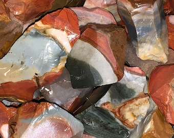 May include: A collection of colorful, multi-colored, and patterned agate stones. The stones are rough and have a natural, unpolished finish.
