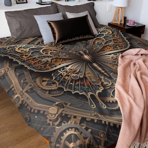 May include: A bedspread featuring a detailed butterfly design with a steampunk aesthetic. The butterfly is rendered in shades of gold, bronze, and blue against a dark gray background with gear-like patterns. The bedding is on a bed with pillows and a pink blanket.