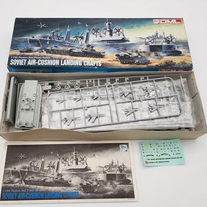 May include: A white ceramic mug with a black handle and the text "But First, Coffee" in a black, bold font. The mug is likely 4 inches tall and holds approximately 12 ounces of liquid.