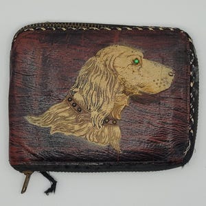 Cartera con cremallera con compartimentos para tarjetas, billetes y monedas. Perro de caza con ojos de gema. Años 50.