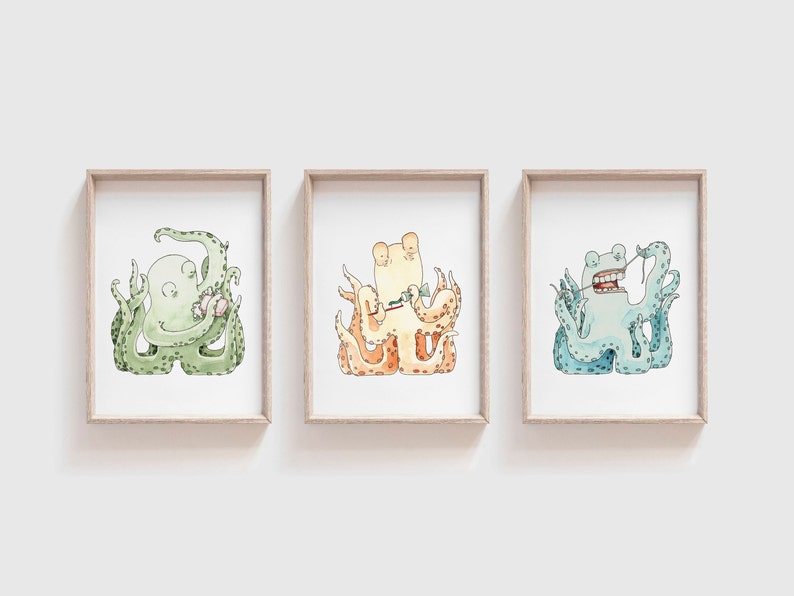 May include: Three framed illustrations of cartoon octopuses. The octopus on the left is green and holding a seashell. The octopus in the middle is orange and holding a toothbrush. The octopus on the right is blue and holding a piece of seaweed.
