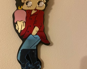 Puede incluir: Un personaje de dibujos animados con cabello negro, camisa roja, pantalones vaqueros azules y zapatos rojos sosteniendo un cono de helado rosa.