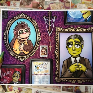May include: A print featuring framed portraits of cartoon characters on a purple patterned background. The portraits include a monkey, a man with green skin, and a menu for a "Pasta Playhouse". A rosary hangs between the frames.