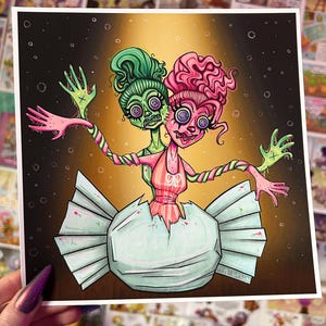 May include: Two-headed, green and pink cartoon figures with large eyes and candy-like features, emerging from a broken candy wrapper. The figures are wearing a pink and white dress with a bow. The background is dark with yellow highlights.