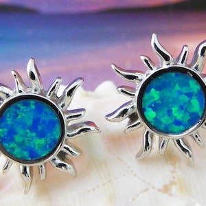 Könnte beinhalten: Ein Paar silberne Sonnenstrahlen-Ohrringe mit blau-grünen Opal-Steinen in der Mitte.