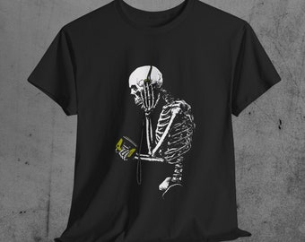May include: Black t-shirt featuring a white illustration of a skeleton listening to music with headphones. The skeleton is holding a yellow music player. The design is printed on a black t-shirt.