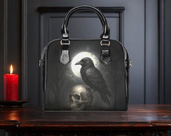 May include: Black leather handbag with a crow perched on a skull in a moonlit forest scene.