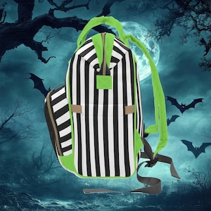 Puede incluir: Una mochila de rayas blancas y negras con detalles verdes. La mochila tiene un compartimento principal grande y un bolsillo frontal m&aacute;s peque&ntilde;o. Las correas son ajustables y la mochila est&aacute; hecha de un tejido duradero.