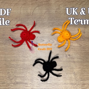 Puede incluir: Tres arañas de ganchillo rojas, amarillas y negras se muestran sobre una superficie de madera. El texto "PDF file" y "UK & US Terms" son visibles. También están las palabras "Butterfly Craft DIY".