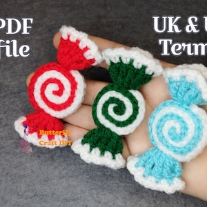 Może przedstawiać: Trzy szydełkowe ozdoby w kształcie cukierków w kolorze czerwonym, zielonym i niebieskim z białymi detalami w kształcie spirali. Ozdoby mają kształt owiniętych cukierków. W obrazie widoczny jest tekst "PDF file" i "UK & US Terms".