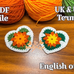 May include: Two heart-shaped crochet appliques with orange and yellow floral designs, bordered by green and white. The image includes balls of orange and green yarn, and text that reads "PDF file" and "UK & US Terms". The words "English only" are also visible.