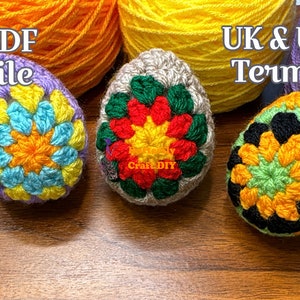 Puede incluir: Tres huevos de Pascua tejidos a crochet en diferentes colores y patrones. Los huevos están sobre una superficie de madera. El texto "PDF file" está en la esquina superior izquierda de la imagen. El texto "UK & US Terms" está en la esquina superior derecha de la imagen.