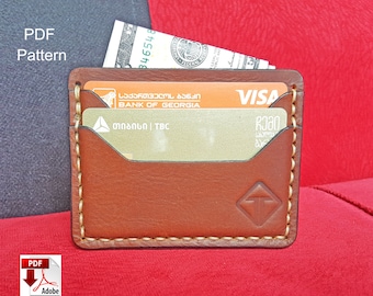 May include: A brown leather wallet with a stitched edge and a small logo on the front. The wallet is open and has two cards inside, one with the text "Bank of Georgia" and the other with the text "VISA".