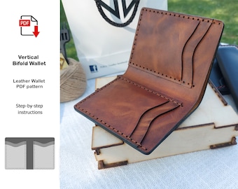 May include: A brown leather bifold wallet with multiple card slots and a stitched edge. The wallet is open and lying on a wooden surface.