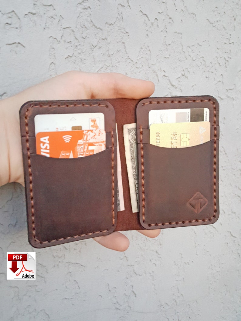 May include: A brown leather wallet with two card slots and a cash pocket. The wallet is open and has a credit card and cash inside.