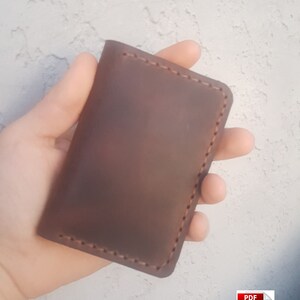 May include: A brown leather wallet with a stitched edge.