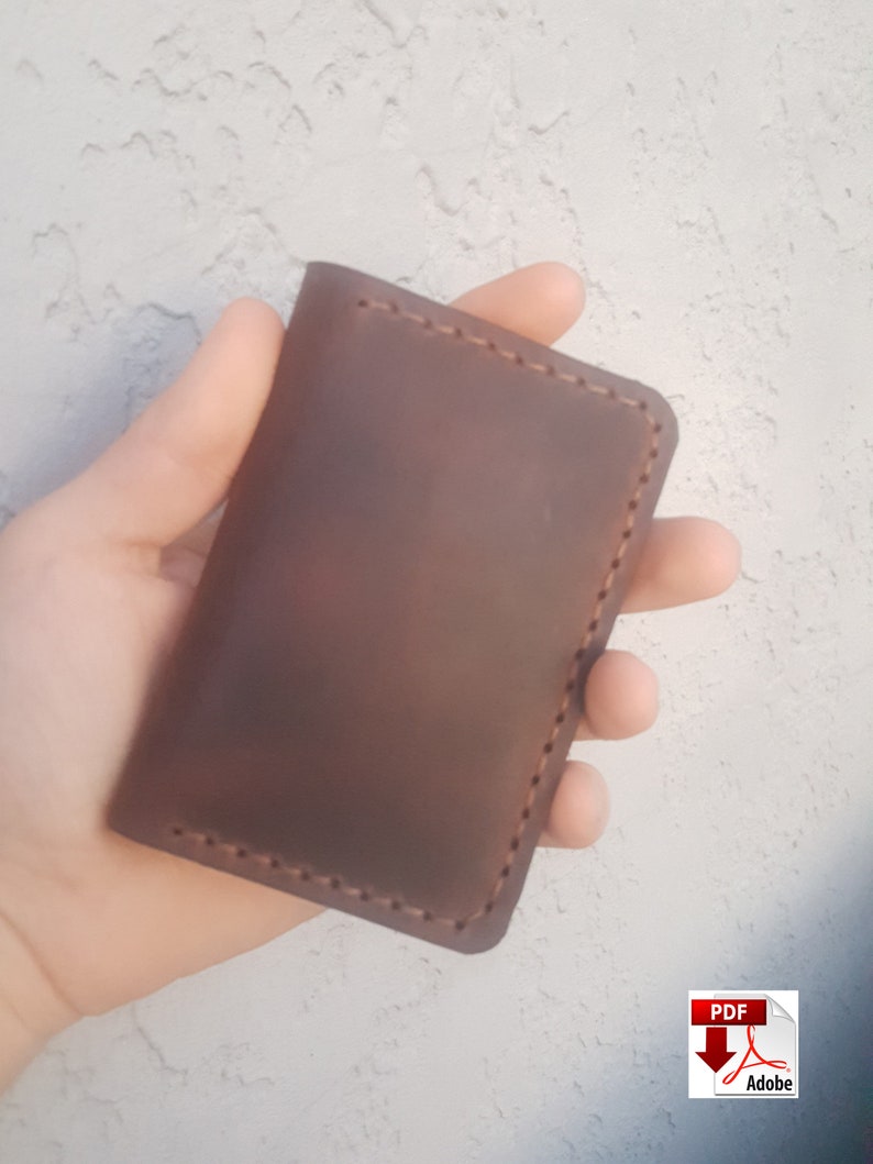 May include: A brown leather wallet with a stitched edge.
