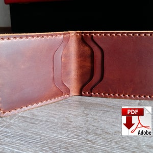 May include: Open brown leather wallet with multiple card slots. The wallet is hand-stitched with a contrasting thread and has a classic bi-fold design. The leather has a natural grain and a rich, warm color.