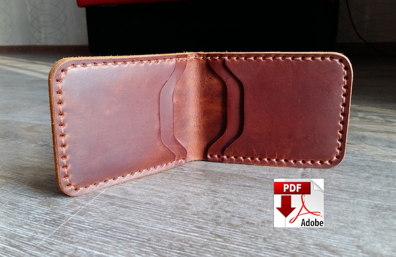 May include: Open brown leather wallet with multiple card slots. The wallet is hand-stitched with a contrasting thread and has a classic bi-fold design. The leather has a natural grain and a rich, warm color.