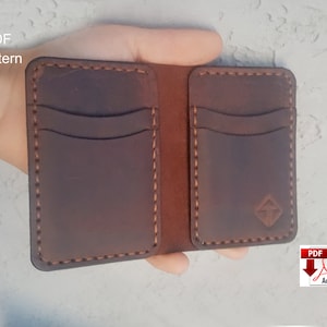 May include: A brown leather wallet with multiple card slots and a stitched design. The wallet is open and held in a hand. The text "PDF Pattern" is visible in the top left corner of the image.