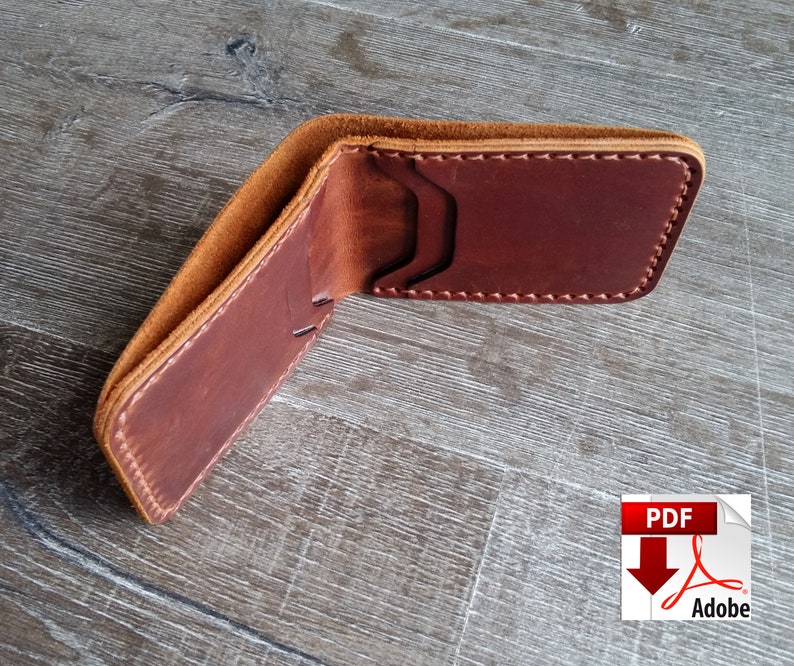 May include: Open brown leather wallet with visible stitching and card slots. The wallet is made of a rich, reddish-brown leather with a lighter tan interior. The wallet is open, displaying its interior design.