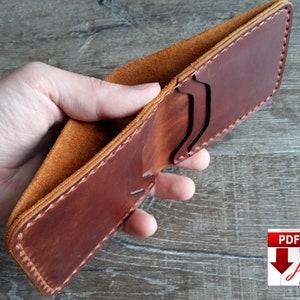 May include: A handmade brown leather wallet with visible stitching and card slots. The interior is a lighter tan color, and the wallet is open, showcasing its design. The image includes a PDF download icon.