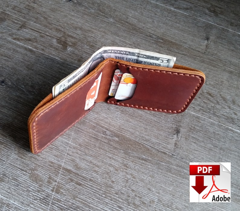 May include: Open brown leather wallet with cash and credit cards visible. The wallet is open, displaying the interior with multiple card slots and a cash compartment. The edges are stitched with a contrasting thread. The wallet is on a wooden surface.