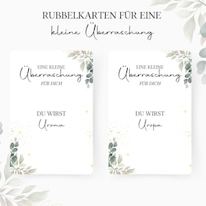 Op de afbeelding: Twee witte kaarten met groen blad en gouden glitter. De tekst op de kaarten luidt "Eine kleine &Uuml;berraschung f&uuml;r dich" en "Du wirst Oma/Opa".