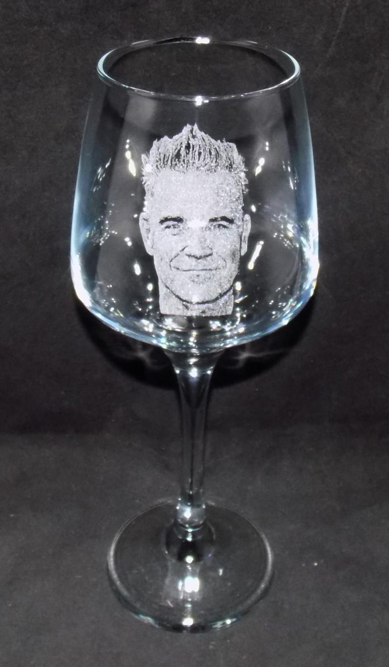 May include: A clear glass wine glass with a personalized etched design of a man's face.