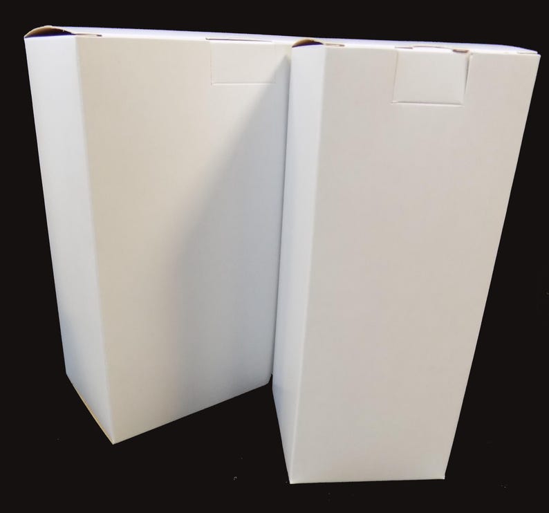 May include: Two white cardboard boxes, side by side, with the flaps closed. The boxes are rectangular and have a plain white surface.