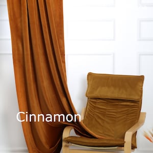 May include: Cinnamon-colored velvet curtain draped next to a matching chair. The chair has a wooden frame and a cushioned seat and back. The word "Cinnamon" is displayed on the curtain.