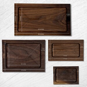 Pode incluir: S&atilde;o apresentadas quatro bandejas de madeira de diferentes tamanhos. A maior bandeja tem 40,6 cm de comprimento e 22,9 cm de largura. A menor bandeja tem 17,8 cm de comprimento e 12,7 cm de largura. Todas as bandejas t&ecirc;m um centro rebaixado.