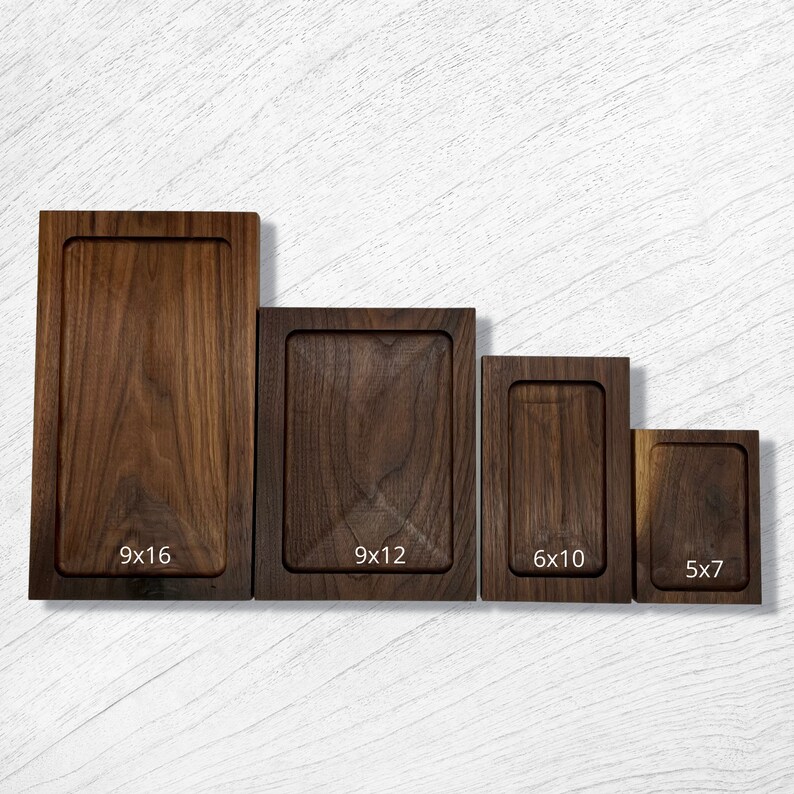 Pode incluir: Quatro t&aacute;buas de servir retangulares de madeira de v&aacute;rios tamanhos. A maior mede 22,86 x 40,64 cm, a seguinte 22,86 x 30,48 cm, seguida por uma t&aacute;bua de 15,24 x 25,4 cm e uma menor de 12,7 x 17,78 cm. Cada t&aacute;bua tem uma borda rebaixada.