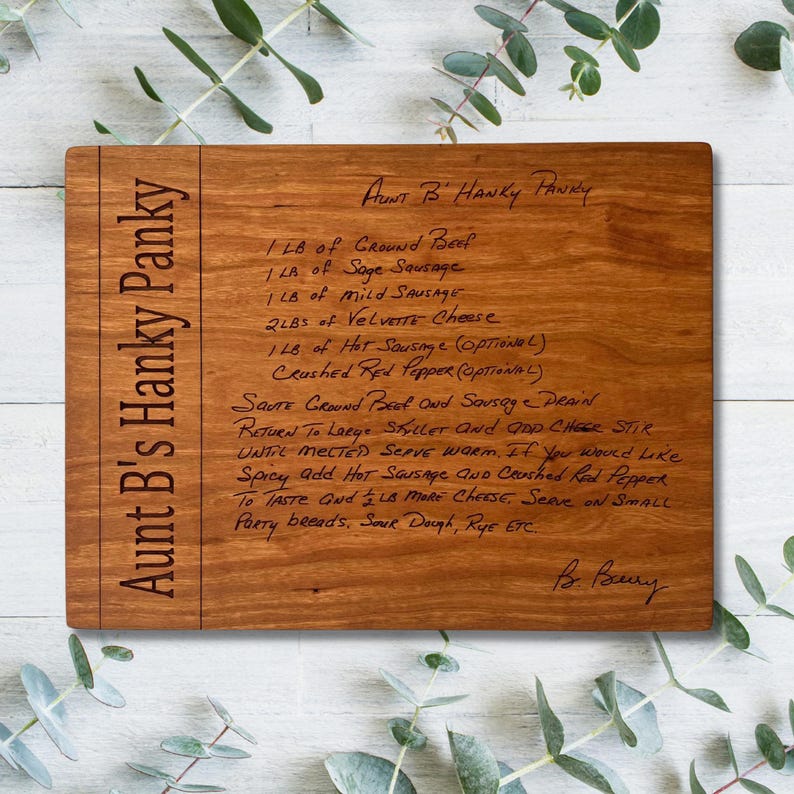 May include: A rectangular wooden cutting board with the text "Aunt B's Hanky Panky" engraved on the side. The board features a handwritten recipe for "Aunt B's Hanky Panky" with ingredients and instructions.