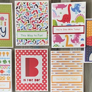 May include: Set of eight greeting cards with colorful patterns and designs. The cards feature phrases like "This Way to Fun!" and "You're Dino-Mite Today!"