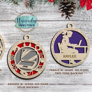 Op de afbeelding: Houten kerstversieringen met een computerthema. Eén toont een mannelijke figuur aan een bureau, een andere een laptop en de laatste een vrouwelijke figuur aan een bureau. Elke versiering heeft een andere achtergrondkleur en bevat tekst zoals "Problem-Solving".