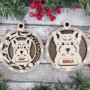 Pode incluir: Dois enfeites de Natal de madeira com retratos de cães e nomes personalizados. Os enfeites são decorados com as palavras "Leal", "Carinhoso", "Amigável", "Companheiro", "Alegre", "Quente", "Adorável", "Confiável" e "Woof".