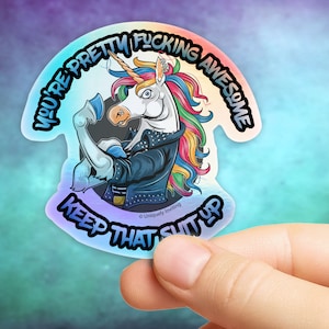 May include: A holographic sticker with a unicorn design, flexing its arm and wearing a studded jacket. The sticker includes the text "YOU'RE PRETTY FUCKING AWESOME" and "KEEP THAT SHIT UP" in a blue font.