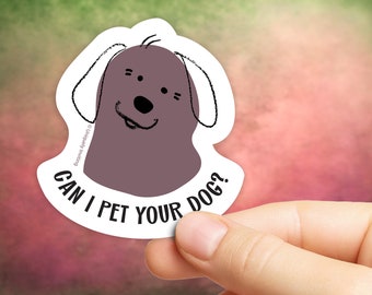 May include: A white sticker with a cartoon dog illustration. The dog is gray with black outlines and a smiling expression. The text "CAN I PET YOUR DOG?" is printed below the dog.