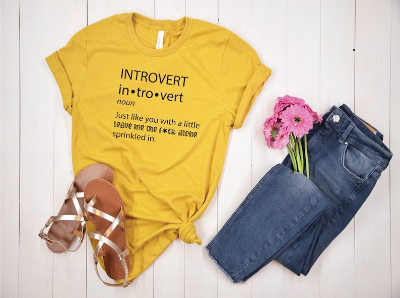 May include: Yellow t-shirt with black text that reads "INTROVERT in.tro.vert noun Just like you with a little leave me the f*ck alone sprinkled in."