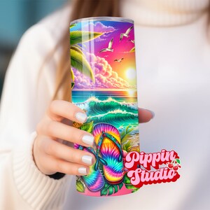 May include: A colorful stainless steel tumbler with a beach scene and tie-dye flip flops. The tumbler has a pink lid and a white background with the text "Pippin Studio" in pink and red.