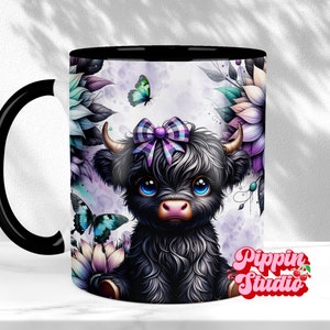 K&ouml;nnte beinhalten: Keramikbecher mit schwarzem Innenraum und Henkel, mit einer Illustration einer schwarzen Highland-Kuh mit lila Schleife, umgeben von Blumen und Schmetterlingen. Der Becher hat den Text "Pippin Studio" in rosa Schrift.