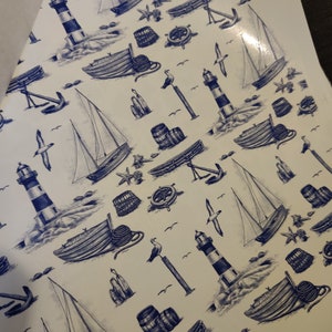Könnte beinhalten: Ein weißer Hintergrund mit einem sich wiederholenden Muster aus blauen nautischen Illustrationen. Das Muster enthält Segelboote, Leuchttürme, Anker, Fässer, Möwen und Ruder.