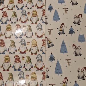 May include: Two sheets of wrapping paper, one with a pattern of gnomes wearing red and white hats and the other with a pattern of blue Christmas trees and stars.