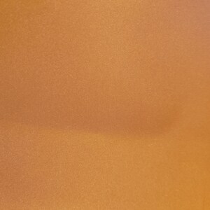 May include: A close-up of a smooth, textured, metallic gold surface.