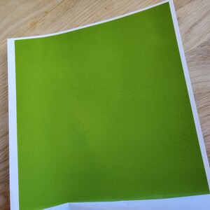 May include: A solid green sheet of paper with a slightly textured surface.